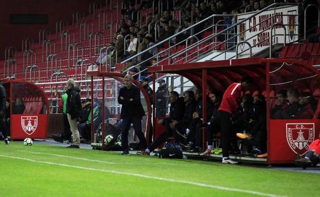 Paco Herrera, a la izquierda, sigue el partido junto al banquillo.
