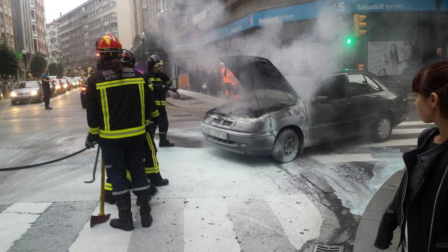 Los bomberos acabab de sofocar el fuego en el coche.
