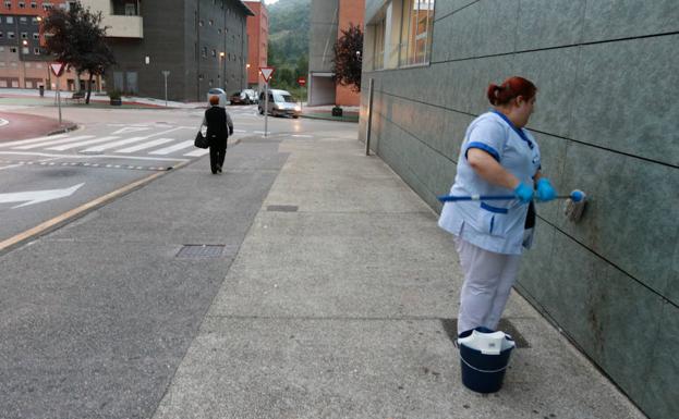 Una mujer limpia la sangre en el lugar del suceso.