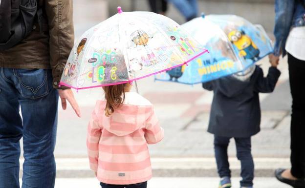 Niños con paraguas en el centro de Oviedo./Álex Piña