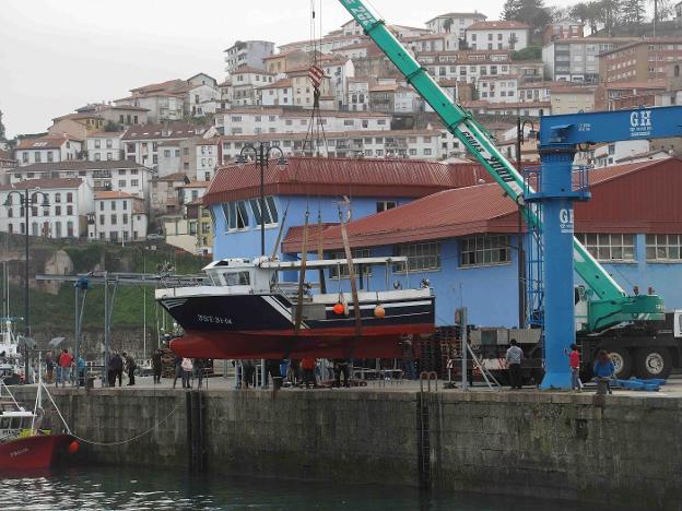 La grúa iza el barco para depositarlo sobre el camión. :: NEL ACEBAL/