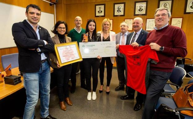 En el centro, la alumna ganadora con su cheque./EL COMERCIO