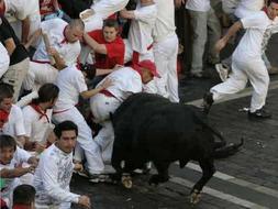 Un toro embiste a un corredor durante una corrida en una edición anterior / ELOY ALONSO. REUTERS/