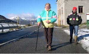 Pilar Fernández camina por la carretera de Leitariegos seguida de Cristina, la única de sus cuatro hijos que se ha quedado a vivir en el alto./
