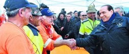 Berlusconi saluda a miembros de Protección Civil en Monticchio, una de las zonas sacudidas por el seísmo. / AFP/