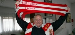 Fueyo, con una bufanda conmemorativa del triunfo en Barcelona y otra de su peña. / SEVILLA/