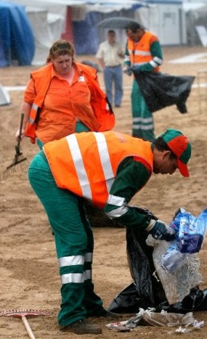 Una trabajadora y dos trabajadores de Emulsa, en una playa. ::
A. PIÑA/