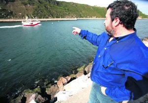 Víctimas. José Antonio Menéndez, hijo de uno de los marineros fallecidos en la galerna señala el pasado jueves a un barco pesquero que entra por la ría. :: ANDRÉS CASTILLO/