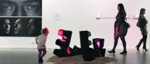 Una niña juega en el centro de la imagen con la instalación de Carlos García. A la izquierda dos instantáneas atrapadas de un vídeo autorretrato de Íñigo Bilbao. :: JORGE PETEIRO/