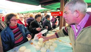 Un productor vende queso de Los Beyos en el certamen de Ponga, en diciembre de 2011. :: NEL ACEBAL/