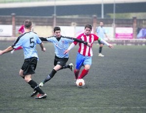 Pelayo Torre intenta robar el balón a un jugador de L'Entregu. ::
J. M. PARDO/