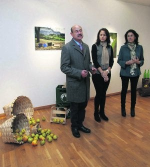 Ramón y Cecilia Alvargonzález, director y subdirectora de la Fundación; con Reyes Ceñal, gerente del Consejo Regulador de Sidra de Asturias, en el centro. Detrás, la fotografía ganadora. ::
PALOMA UCHA/