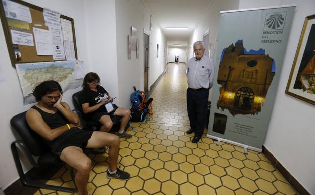 Pablo Sánchez, encargado del Albergue, junto a dos peregrinos en el pasillo del albergue. 