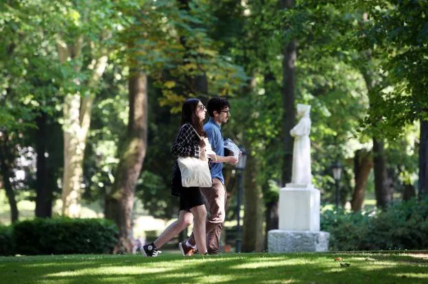 Una pareja de paseo por el Campo de San Francisco. / ALEX PIÑA