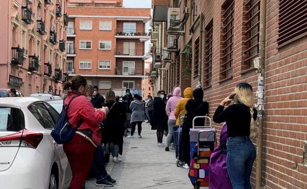 Ciudadanos esperando ante un economato de Cáritas. /R. C.