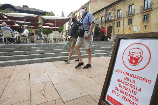 Un cartel recuerda la obligatoriedad del uso de la mascarilla en una terraza de la plaza Porlier. / MARIO ROJAS