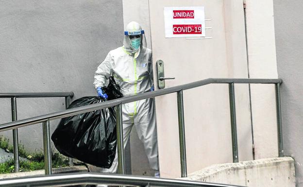 Sanitario saca la basura al salir de una unidad donde se trata a pacientes infectados de Covid en un hospital/MANU CECILIO