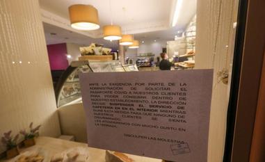 Un cartel explica los motivos del cierre del interior a la puesta del establecimiento./MARIETA