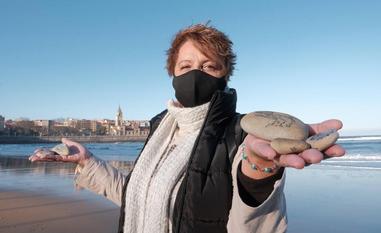 Denise Álvarez sostiene algunas de sus piedras viajeras en la playa de San Lorenzo./CAROLINA SANTOS