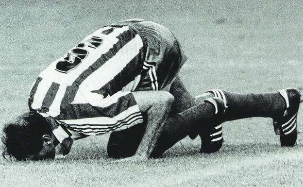Quini besa el césped de El Molinón al retirarse en el partido homenaje ante el Madrid en agosto de 1987